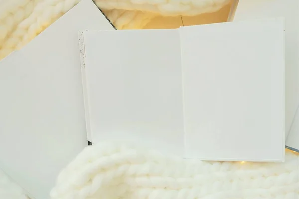 Winter books. Winter cozy reading. white books with blank sheets with knitted scarf and garland.Cozy mood. Winter Season Christmas books. — Stockfoto