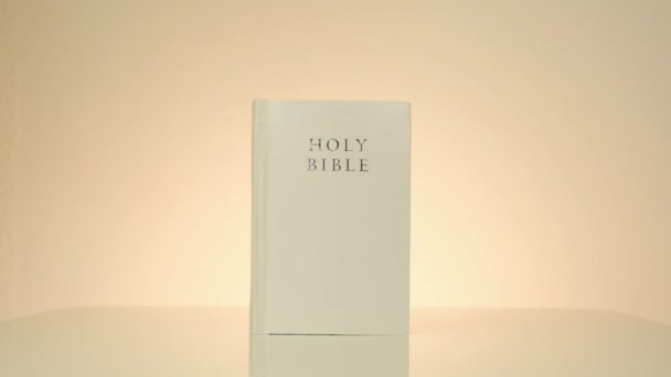 Heilige Bijbel.Christelijke religie. Schrift boek. wit bijbelboek over lichtgele achtergrond — Stockvideo