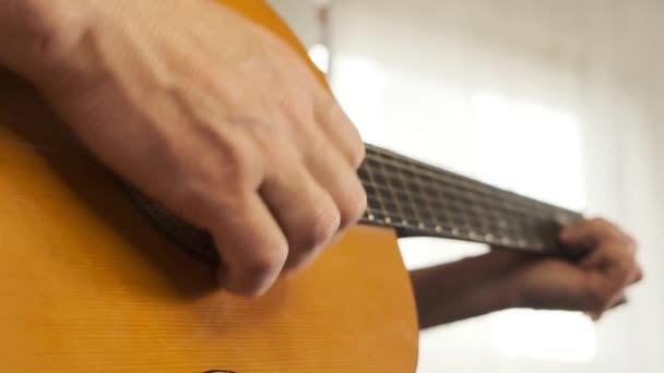 Hand op de snaren van een gitaar.Gitaarspeler.Muziek en muziekinstrumenten concept. Melodie en muziek. — Stockvideo