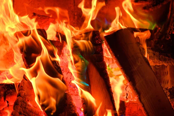 Fiamma. Fuoco e fiamme Scintille e fiamme primo piano. Camino con tronchi e fiamme.Fiamma multicolore.legna da ardere in falò. — Foto Stock