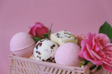 Bath bombs and truffles with rose petals in a pink box on a pink background.Bath bombs with rose extract.Beauty and aromatherapy. Flower Bath Bombs.Organic cosmetics with rose extract