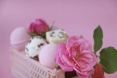 Flower Bath Bombs.Bath bombs and truffles with rose petals in a pink box on a pink background.Bath bombs with rose extract.Beauty and aromatherapy. Organic vegan eco cosmetics with rose extract. 