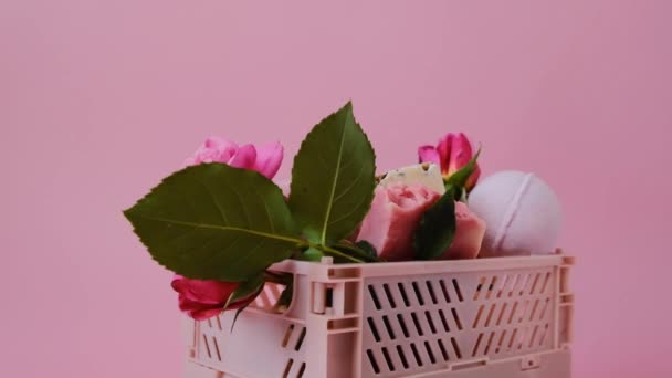 Бомби для ванни з пелюстками троянд у рожевій коробці крупним планом на рожевому тлі. Бомби для ванни з екстрактом троянд. Краса та аромотерапія. Бомби з квіткової ванни. Органічна веганська екологічна косметика з екстрактом троянди — стокове відео