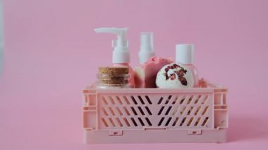 cosmetics with rose extract.Bath bombs and truffles with rose petals,Pink cosmetic bottles in a pink box close-up on a pink background.Beauty and aromatherapy. Flower Bath Bombs.