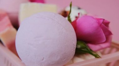 Bath bombs and truffles with rose petals in a pink box close-up