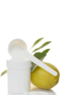 C vitamini tozu, beyaz ölçü kaşığı, beyaz kavanoz ve yeşil yapraklı limon. Vitamin ve mineraller. Sağlık ve Tıp Konsepti.