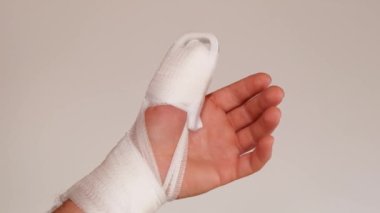 Kırık parmak. Parmağında bandaj ve sargı bezi var. Beyaz bandajlar