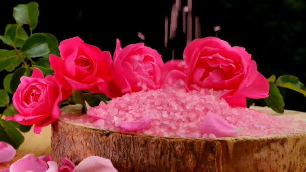 Rozenzout op een houten zaag.Aromatherapie en cosmetica.rose bloemen en roze cosmetica zout.Biologische cosmetica zout met roos extract — Stockvideo