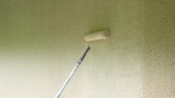 Rulla måla väggarna i beige color.wall målning.Home renovering utanför.Hand av en dekoratör måla en vägg med en rulle. — Stockvideo