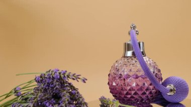 Eflatun parfümü ve lavanta çiçekleri bej arka planda. Rotasyon. Aromaterapi ve güzellik. Lavanta kokusu..