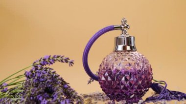 Bej bir arka planda lavanta parfümü ve lavanta çiçekleri. Rotasyon. Aromaterapi ve güzellik kavramı. Lavanta özü.