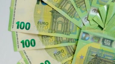 100 avroluk bir geçmiş. Banknotlar beyaz bir zemin üzerine kurulmuş 100 avro. Avrupa Birliği para birimi