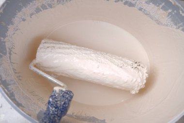 Paten ve boya. Boyalı bir kovada inşaat işleri. Bej tonlarda ev boyası. Duvar boyası ve yenileme. 