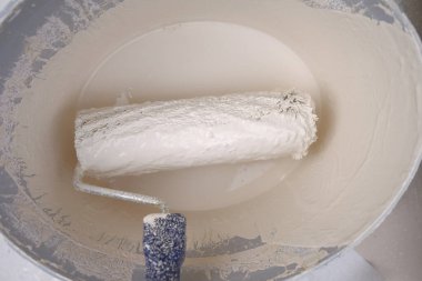 Paten ve boya. Bej boyalı bir kovada inşaat işleri. Renkli ev boyası. Duvar boyası.