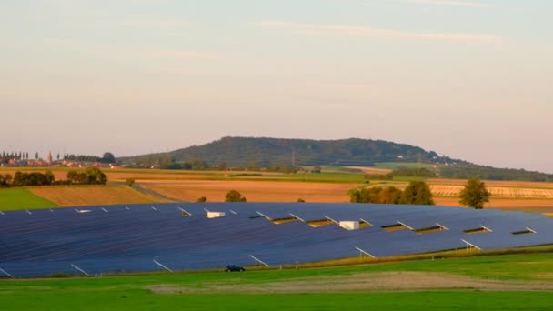 Zonnepanelen boeren op een zonnige dag in een groen veld.Hernieuwbare energie.Alternatieve energiebronnen. — Stockvideo