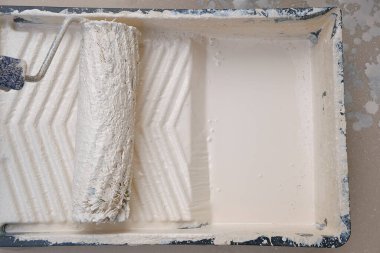  Paten ve boya. Bej boyalı bir konteynırda rulo. Bej renkte ev boyası..