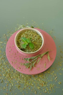  Stevia rebaudiana.Stevioside Sweetener . Yeşil arka planda pembe kaidede yuvarlak bir fincanda sade ve yeşil bir stevia. Stevioside Sweetener. Organik düşük kalorili tatlandırıcı