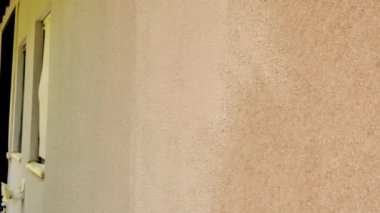 Duvar boyası. Paten ve boya. Dışarıda tadilat var. Paten evin duvarlarını bej rengi kumla boyuyor. Bej tonlarda ev boyuyor.. 