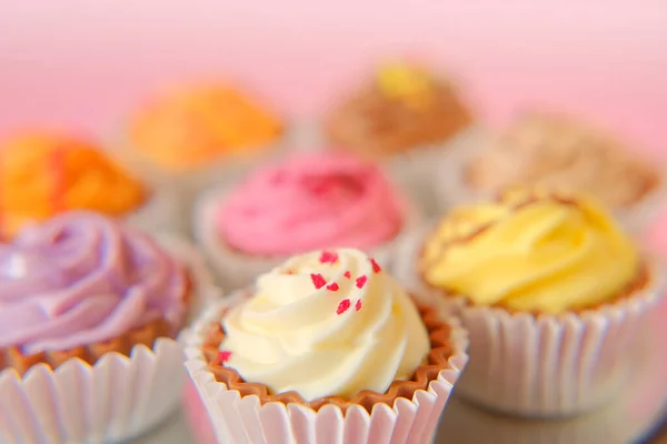 Grädddessert. Grädde cupcakes.cakes på en rosa bakgrund. Blandat sött bord. Sötsaker och desserter. Bakverk — Stockfoto