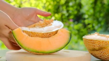 Kadın ellerinde kavun kesiği. İştah açıcı yaz meyveleri. Olgun sarı kavun