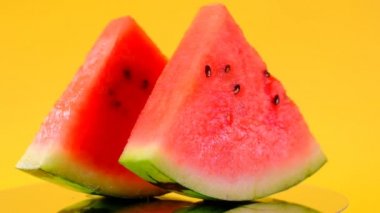 Kesik karpuz. Sarı arka planda karpuz dilimleri. Döndürme. Olgun İştah açıcı yaz meyveleri.