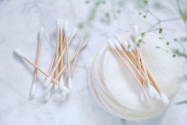  Sıfır kayıp. Organik pamuk tomurcukları, yeniden kullanılabilir doku kozmetik süngerler ve mermer zemin üzerinde beyaz çingene çiçekleri. Makul tüketim