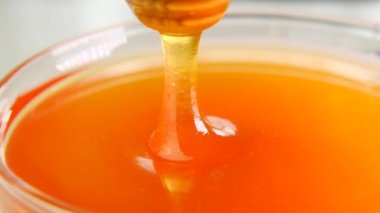 Tatlım, bal için cam bardağa yapış. Yavaş ol. Tatlıyı iyileştir. Bal dokusunu yakından çek. Doğal biyolojik arıcılık ürünleri