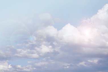 Cennet arka planı. Bulutlar. Beyaz bulutlar ve açık mavi gökyüzünde güneş ışığı. Gökyüzü açık renkli renklerde. Pastel renklerde cennet arkaplanı