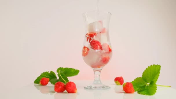 Bebida de fresa.Agua mineral espumosa se vierte en un vaso con hielo y fresas.Refrescante cóctel de verano.Bebidas de verano. — Vídeos de Stock