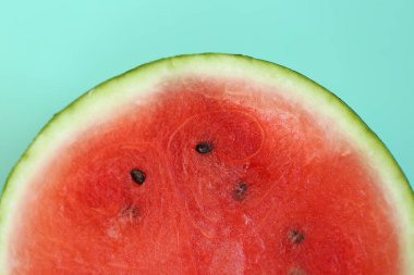 Karpuz yarısı. Yeşil arka planda karpuz kesiği. Karpuz hamuru. İştah açıcı yaz meyveleri..