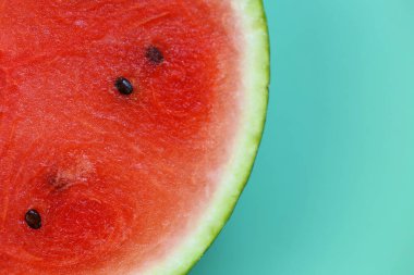 Yeşil arka planda karpuz kesiği. Karpuz hamuru. Olgun kırmızı karpuz yarısı. İştah açıcı yaz meyveleri..