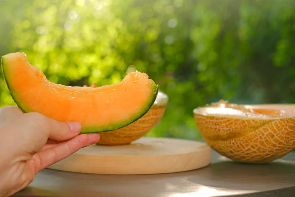 Melon.piece of ripe melon.Melon in a cut in female hands. Appetizing summer fruits. Womens hands cut a melon