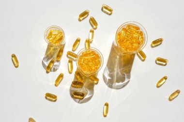 Omega yağ asitleri. Beyaz bir arka planda laboratuvar şeffaf şişelerinde balık yağı jelatin kapsülleri. Sağlıklı beslenme ve gıda takviyeleri. Doğal destek ve vitamin.