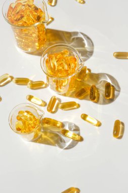 Beyaz arka planda şeffaf mataralarda balık yağı. Sağlıklı beslenme ve gıda takviyeleri. Omega yağ asitleri. Balık yağı kapsülleri. Doğal destek ve vitamin.