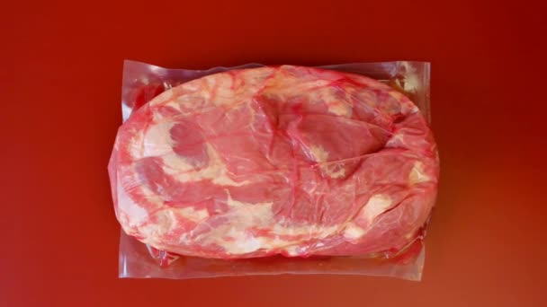 Vlees en varkensvet in vacuümzakken. Vleesproducten. Eiwitvoeding. Biologisch vlees van boerderij.Rood vlees op rode achtergrond — Stockvideo