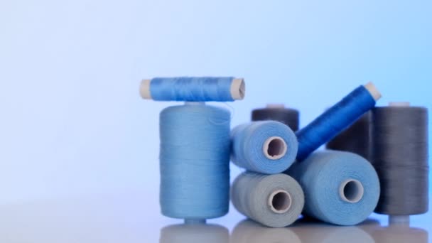 Sewing threads set.Blue and gray thread spools on a light blue background.Needlework and sewing concept.Hobby and handicraft — Stock Video