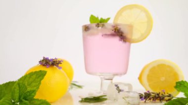 Lavanta kokteyli Summer içiyor. Lavanta limonlu içecek ve lavanta çiçekleri. Yaz kokteyli ferahlatıcı. yavaş çekim.