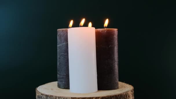 Adventsljus. Julen kom fyra ljus. Fyra brinnande vaxljus på ett träsnitt på mörkgrön bakgrund.Rotation. — Stockvideo