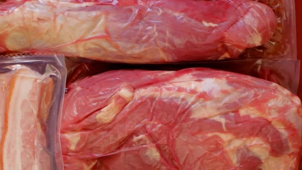 М'ясо і свинячий жир у вакуумних пакетах. М'ясні продукти. Білкове харчування. Ферма органічне біологічне м'ясо. Червоне м'ясо на червоному тлі — стокове відео