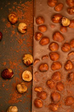 Geçmişinde fındık ve kakao tozu olan çikolata çubuğu. Fındıklı çikolata tatlısı. Koyu bir arka planda çikolata..