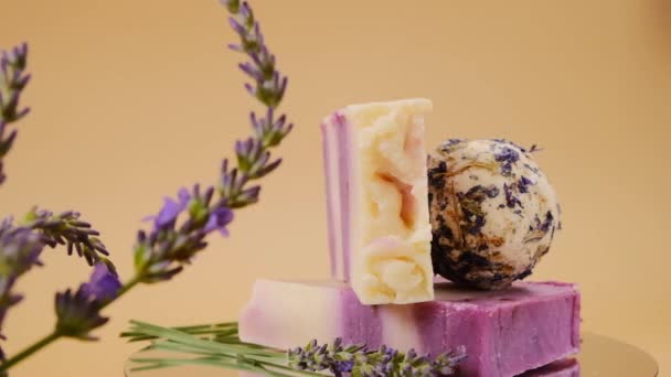 Lavendel bad tryffel och tvål, lavendel grenar på en beige bakgrund. Ekologiska naturliga tvålar och bad bomber med lavendel doft — Stockvideo