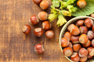 Fındıklar, ahşap bir masada yeşil bir fincanın içinde. Yeşil yapraklı fındıklar. Fındık hasadı. Olgun organik fındıklar. Sağlıklı şişmanlar. Fındık hasadı. Yukarıdan görüş..