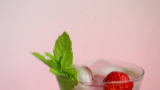 Água de morango com gelo e morangos em uma taça de vidro e morangos com folhas — Vídeo de Stock