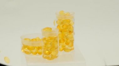 Beyaz bir arka planda laboratuvar şişelerinde balık yağı kapsülleri. Morina yağı. Omega-3.Uçan kapsüller Balık yağı. Omega yağ asitleri. Doğal Vitamin ve Beslenme İlaçları..