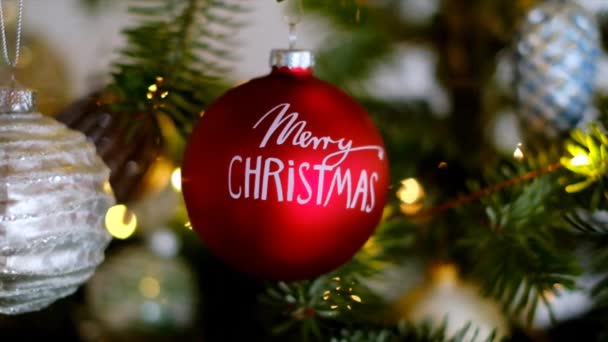 Weihnachtskugel aus nächster Nähe am Weihnachtsbaum mit leuchtenden Girlanden. Winterurlaub. Weihnachtszeit — Stockvideo