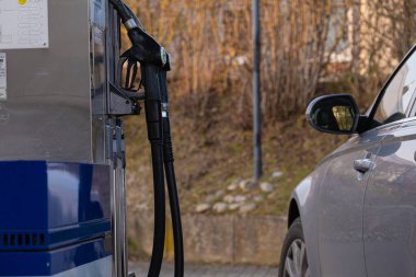 Benzin istasyonu. Benzin istasyonundaki araba. Araba, yakıt ikmali silahları ve eldivenler. Avrupa 'da yakıt fiyatı. Benzin istasyonu.