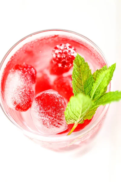 Raspberry cocktail.Summer drink.raspberry pink drink.Ice cubes with raspberries in a glass with water, berries and raspberry leaves . refreshing cocktail. —  Fotos de Stock