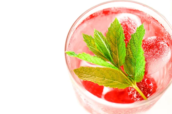 Raspberry pink drink.Ice cubes with raspberries in a glass with water, berries and raspberry leaves on a white wooden table. refreshing cocktail.Raspberry cocktail.Summer drink. — Foto Stock