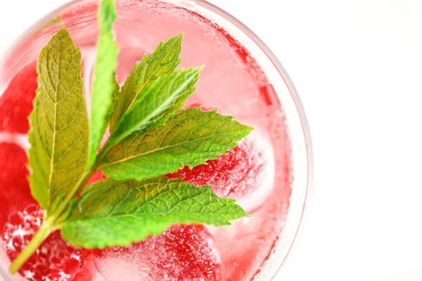 Summer drink.raspberry pink drink.Ice cubes with raspberries in a glass with water, berries and raspberry leaves on a white wooden table. refreshing cocktail. — Foto Stock