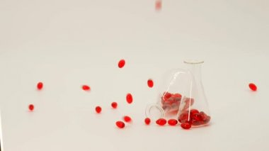 Kril yağı kırmızı jelatin kapsülleri laboratuvar şişelerinde. Omega 3 yağ asitlerinin kaynağı. Uçan kapsüller beyaz arka planda kırmızı kril yağı. Doğal takviyeler ve vitamin.
